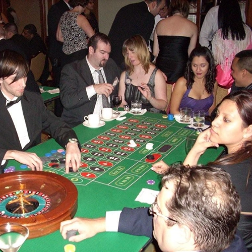 Holiday casino party with guests at a roulette table.